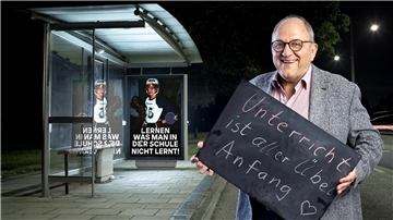 Ein Mann mit einem Schild in der Hand. Es trägt die Aufschrift "Unterricht ist aller Übel Anfang". Als Rektor der Alemannenschule in Wutöschingen hat Stefan Ruppaner Unterricht und Klassenräume abgeschafft.  