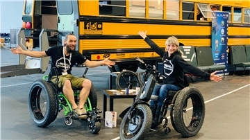 Stefanie Hoyer und ihr Freund Benjamin Hermann posieren auf einer Messe in Bremen vor ihrem Bus.