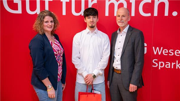 Stefanie Klüver, Leiterin Geschäftsstelle Kreissportbund Cuxhaven und Rolf Sünderbruch, Vorstandsvorsitzender der Weser-Elbe Sparkasse überreichen Karateka Aaric Liam Lück (Mitte) das Sportstipendium für 2025.