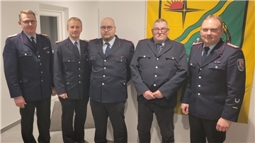 Fünf Feuerwehrleute in einer Reihe. 