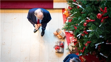 Stephan Weil (l) steht in der Staatskanzlei vor einem Weihnachtsbaum.