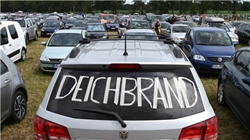 Ein silbernes Auto mit Deichbrand-Schriftzug auf der Heckscheibe steht auf dem Parkplatz neben anderen Fahrzeugen.