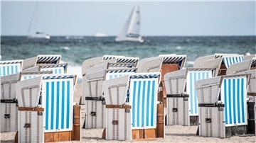 Strandkörbe am Ostseestrand von Warnemünde. Die neue Woche beginnt meist sonnig und trocken.