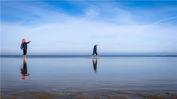 Strandspaziergänger sind an der Ostsee am Wohlenberger Wieck unterwegs.