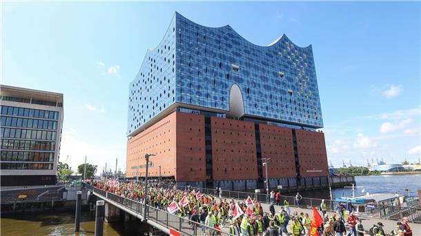 Warnstreik legt mehrere Häfen in Norddeutschland lahm Streikende Hafenarbeiter ziehen bei einer Demonstration an der Hamburger Elbphilharmonie entlang.