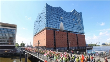 Streikende Hafenarbeiter ziehen bei einer Demonstration an der Hamburger Elbphilharmonie entlang.