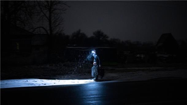 Stromausfall in Kolytschiwka: Ein Mann behilft sich mit einer Stirnlampe.