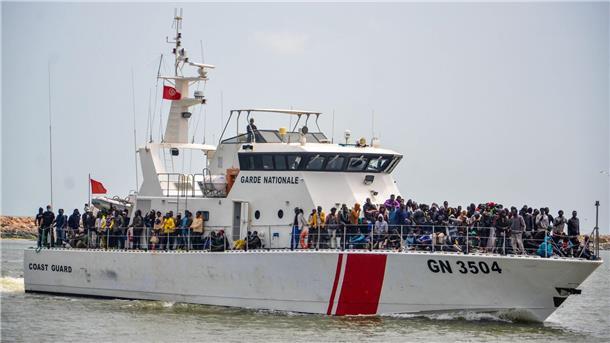 Subsaharische Migranten stehen an Bord der Küstenwache in Tunesien.