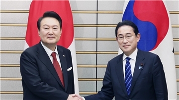 Südkoreas Präsident Yoon Suk Yeol (l.) und Japans Premier Fumio Kishida reichen sich vor ihren Gesprächen die Hände.