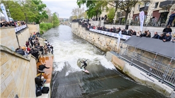 Surfer testen die Leinewelle auf dem Fluss Leine in der Altstadt.