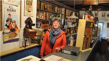 Susanne Schiller, Betreiberin des Ladens im Historischen Kaufhaus, steht hinter der zweiten historischen Ladentheke, die sich im musealen Bereich des Kaufhauses befindet.
