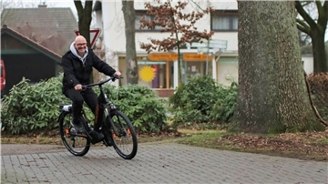 Ein Radfahrer fährt auf den Hof eines Fahrradladens.
