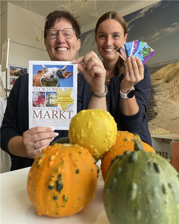 Herbstmarkt und offener Sonntag: In Nordenham dreht sich wieder alles um Ochsen Svenja Faehse von NMT präsentiert den Flyer zum Ochsenmarkt, ihre Kollegin Sandra Jankowsky die neuen Nordenham-Gutscheinkarten.