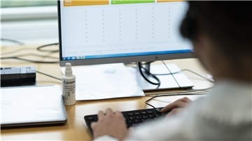 Symbolbild: Ein Mitarbeiter des Gesundheitsamtes zur Kontakt-Nachverfolgung sitzt im Contact Tracer Zentrum an einem Computern.