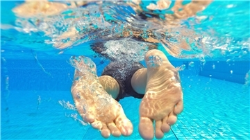 Symbolbild: Ein Schwimmer taucht durch klares Wasser in einem Schwimmbad. Foto: Julian Stratenschulte/dpa 