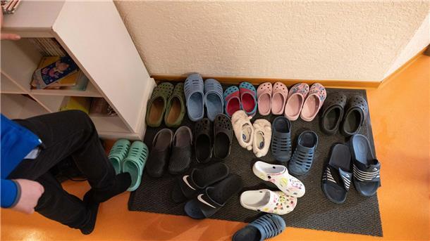 Symbolbild:  Hausschuhe stehen vor einem Zimmer im Kinderheim.