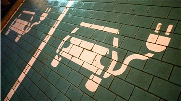 Symbole markieren Parkplätze mit einer öffentlichen Ladesäule für Elektroautos.