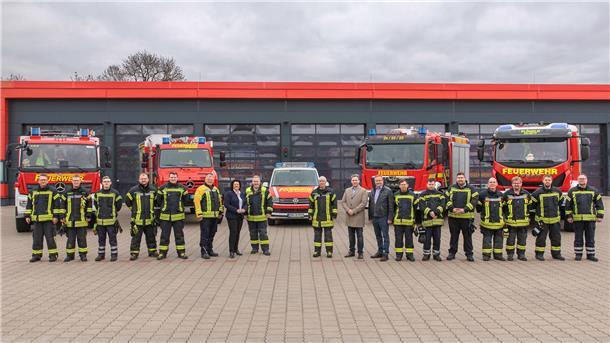 Feuerwehrkräfte und neue Fahrzeuge vor dem Feuerwehrhaus Langen
