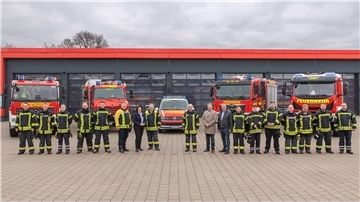 Feuerwehrkräfte und neue Fahrzeuge vor dem Feuerwehrhaus Langen
