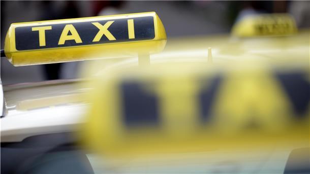Ein Taxi-Schild auf einem Autodach.