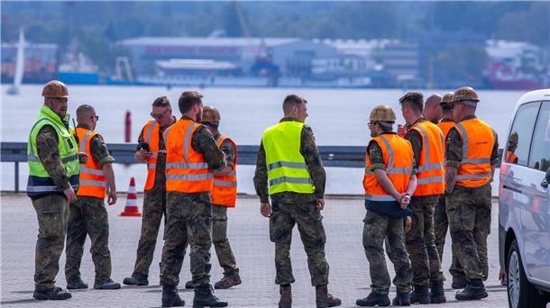 Teilnehmer der Übung National Guardian 24 der Bundeswehr warten im Seehafen auf die verspätete Ankunft eines Transportzugs mit Panzern.