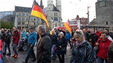 Teilnehmer einer Demonstration des Bündnisses „Bewegung Halle“ ziehen durch Halle/Saale.