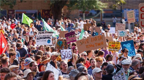 Teilnehmer einer Demonstration gegen den Klimawandel und für Klimagerechtigkeit stehen auf dem Platz der Alten Synagoge in Freiburg.