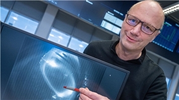 Thomas Klinger, Direktor am Max-Planck-Institut für Plasmaphysik, zeigt ein Bild eines Wasserstoffplasma.