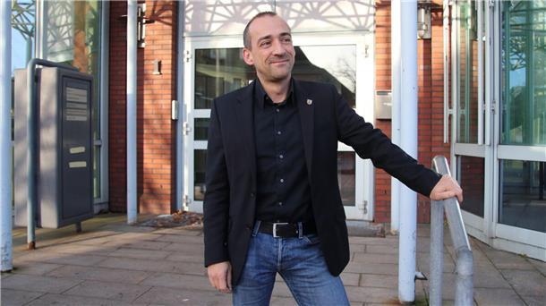 Früherer Cuxland-Wirtschaftsförderer Thomas Lötsch ist im tiefen Süden gelandet Thomas Lötsch steht vor dem Eingang eines Gebäudes. Er hält eine Hand an einem kurzen Treppengeländer. Er trägt Jeans, dunkles Hemd und dunkles Sakko.