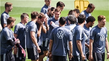 Thomas Müller (5.v.l.) wird von seinen Mitspielern und Bundestrainer Joachim Löw (5.v.r.) nach einem verlorenen Spiel beim Aufwärmen „geschnipst".