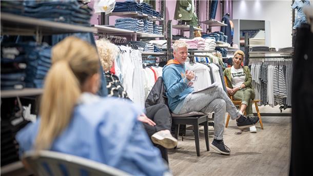 Thorsten Bremicker (Mitte), Geschäftsführer des Happy Jeans Shops, bespricht die Wiederöffnung des Geschäfts mit seinen Angestellten.