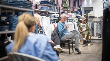 Thorsten Bremicker (Mitte), Geschäftsführer des Happy Jeans Shops, bespricht die Wiederöffnung des Geschäfts mit seinen Angestellten.