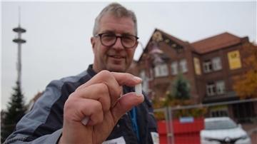 Ein Mann hält einen Kunststoff-Dübel