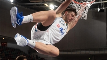 Ein Basketballer hängt sich nach einem Dunking an den Korb. Es ist Till Isemann von den Eisbären,