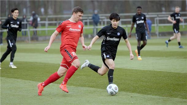 Zwei Fußballer kämpfen um den Ball.