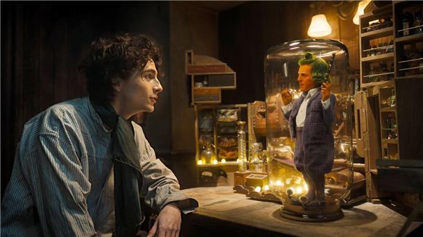 Baden in Schokolade - Timothée Chalamet ist „Wonka“ Timothée Chalamet (l) als Willy Wonka und Hugh Grant als Oompa Loompa in einer Szene des Films „Wonka“.