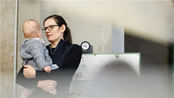Tischlermeisterin Johanna Röh mit ihrem Kind in der Werkstatt ihres Betriebes.
