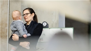 Tischlermeisterin Johanna Röh mit ihrem Kind in der Werkstatt ihres Betriebes.
