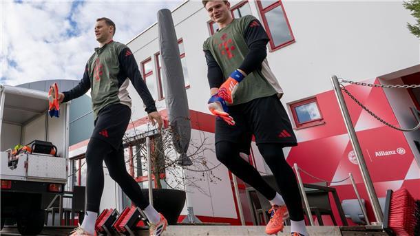 Torwart Manuel Neuer (l) und Ersatzkeeper Jonas Urbig auf dem Weg auf den Trainingsplatz.