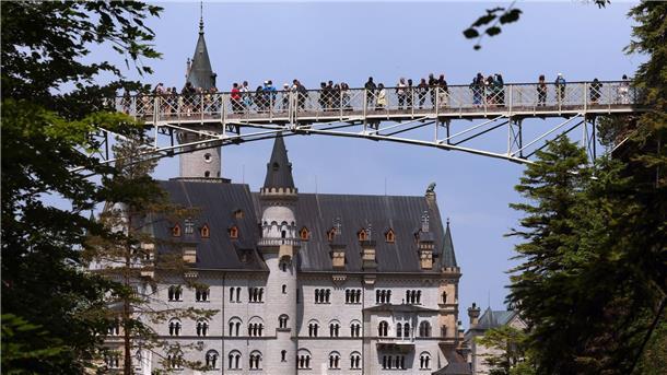 Touristen stehen auf der Marienbrücke vor dem Schloss Neuschwanstein. (Archivbild)