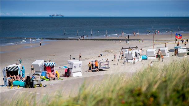 KI: Chance und Herausforderung für den Tourismus Touristinnen und Tourstien sitzen bei sonnigem Wetter in Strandkörben am Strand der Insel Wangerooge.