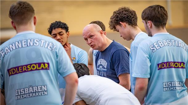 Ein Basketball-Trainer spricht in einer Auszeit mit seinen Spielern. Es ist Tomasz Kumaszynski mit der U19-Mannschaft der Eisbären.