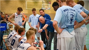 Trainer Tomasz Kumaszynski (Mitte) und das NBBL-Team der Eisbären freuten sich über den ersten Saisonsieg.