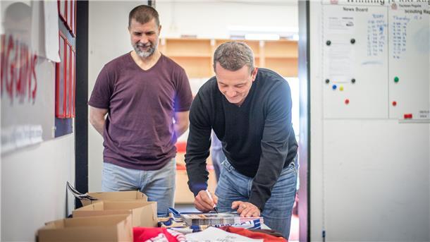 Trainerduo Martin Jiranek (links) und Thomas Popiesch signieren die Playoff-Hefte, die zu etwas Besonderem werden könnten.