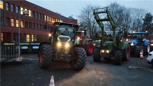 Traktoren vor einem dreigeschossigen Gebäude