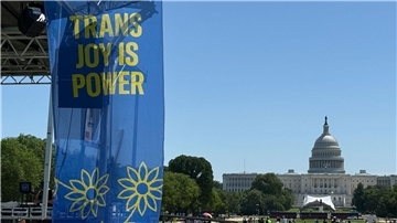 „Trans joy is power“ steht auf einem Banner an einer Bühne vor dem Kapitol am ersten Tag der Worldpride. 
