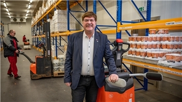 Ralf Forner steht im Lagerraum vor einem Regal.