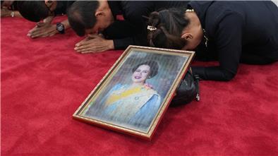 Trauernde beten in Bangkok mit einem Porträt der Königinmutter Sirikit.