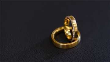 Trauringe auf schwarzem Untergrund. Eine ehrliche Finderin hat eine Schachtel mit zwei Ringen auf der Straße gefunden, sich bei der Polizei gemeldet und damit einen Heiratsantrag an Heiligabend möglich gemacht (Symbolbild).
