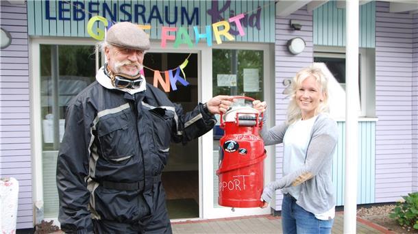 Treckerfahrer Helmuth Kirch aus Flögeln und Yvonne Stünkel von „Lebensraum Kind“ sind zufrieden: Auf seiner Spendentour zwischen Bad Bederkesa und der Eifel konnte Kirch 1500 Euro für „Lebensraum Kind“ sammeln. Das Geld wurde in einer Kanne übergeben.